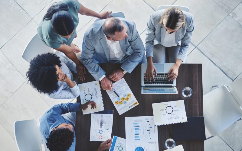 Conference team, table and discussion about documents at corporate meeting for data development. An.